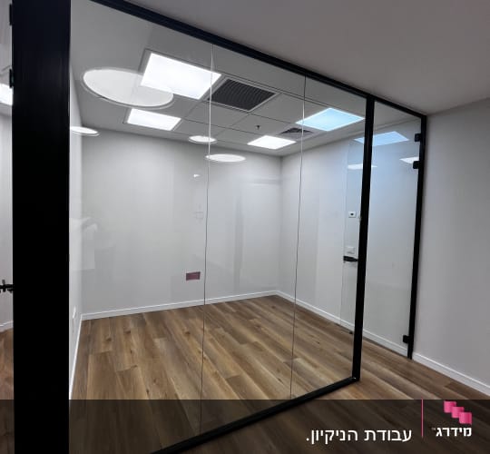 חדר עם רצפת עץ ודלת זכוכית